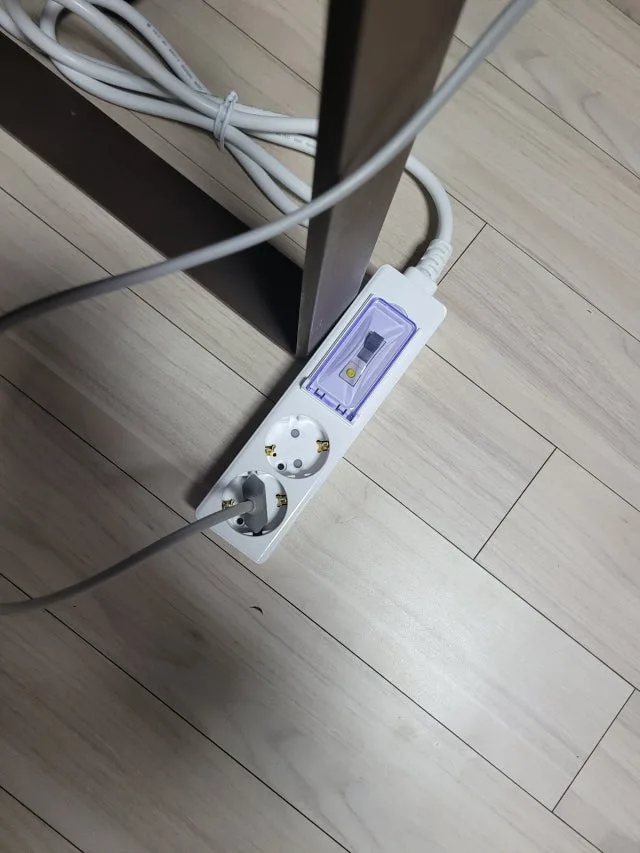 바닥 공간에 놓인 써보니 고용량 멀티탭과 전선 방향