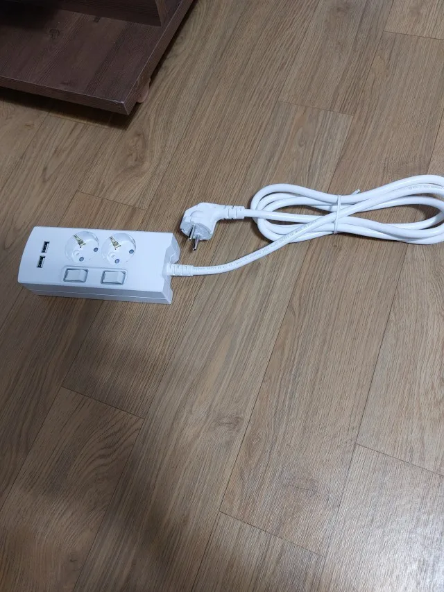 원목 바닥 위에 놓인 써보니 USB 멀티탭과 전선