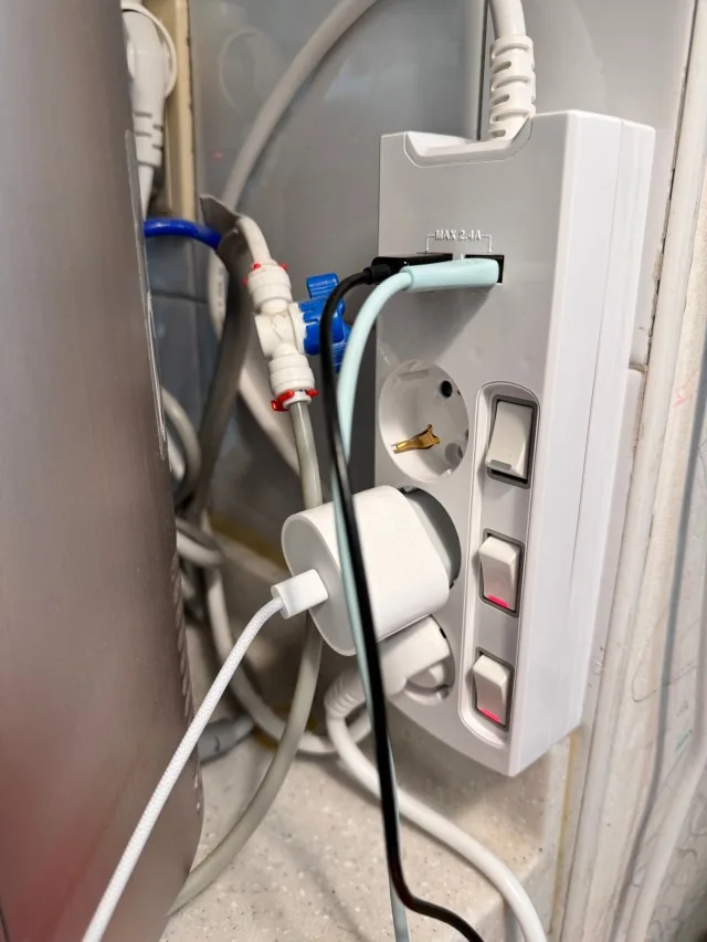 여러 USB 케이블과 전원 어댑터를 함께 연결한 집 안 충전 공간