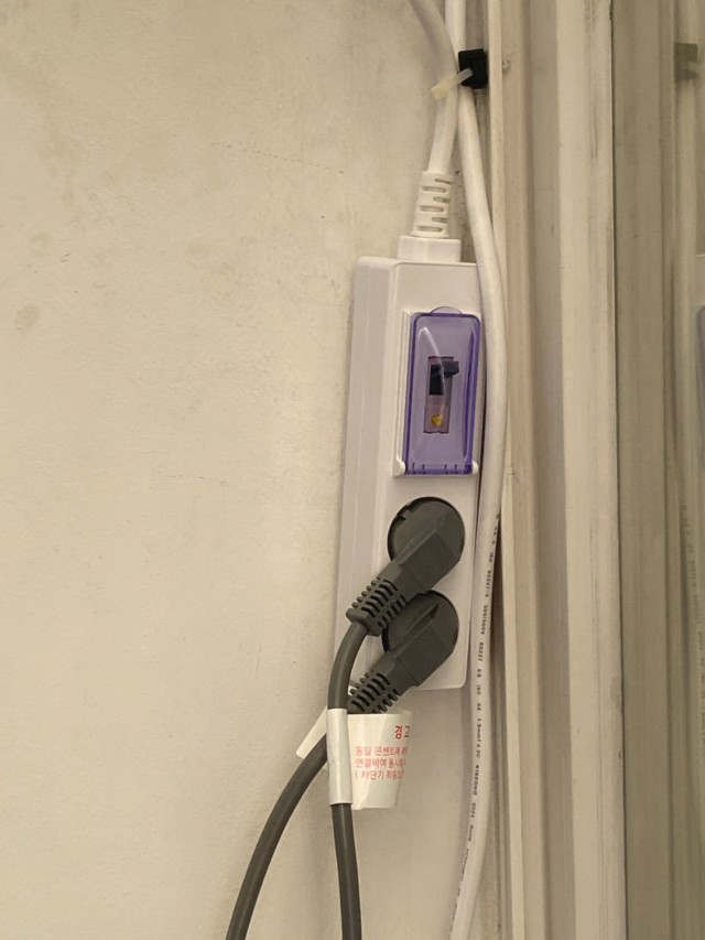 차단기 덮개와 두 플러그가 보이는 써보니 고용량 2구 멀티탭