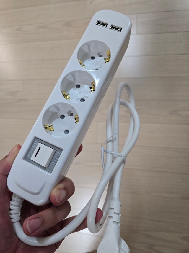 손에 든 흰색 USB 3구 통합스위치 멀티탭과 전원선