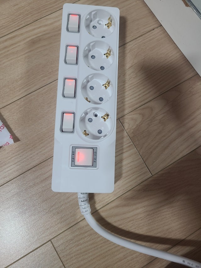멀티탭 보호 기능을 갖춘 써보니 4구 개별스위치 멀티탭, 개별 스위치와 아래쪽 과부하차단 스위치가 켜진 모습